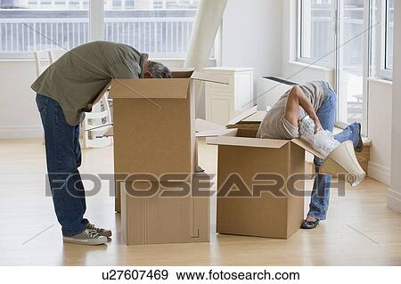 Stock Photo - Couple unpacking moving boxes. Fotosearch