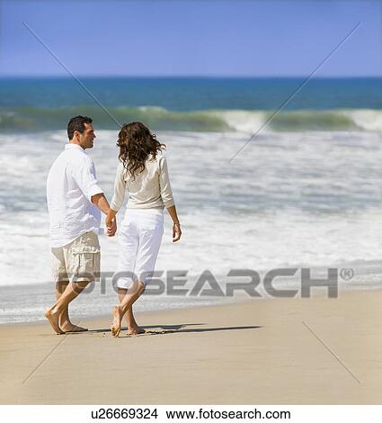 Picture - Couple walking on beach. Fotosearch