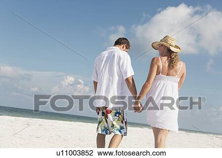 Couple walking on beach View Large Photo Image Stock Image - Couple walking on beach. Fotosearch