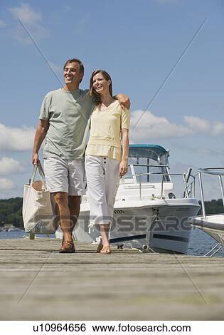 Couple walking on boat dock View Large Photo Image Stock Photograph - Couple walking on boat dock. Fotosearch