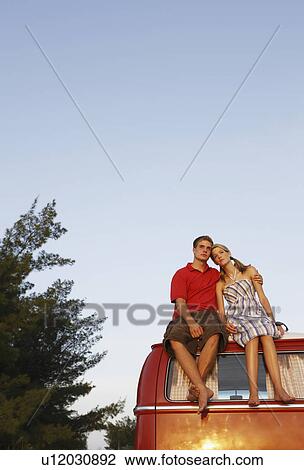 Couple watching ocean sunset from top of van View Large Photo Image Stock Image - Couple watching ocean sunset from top of van. Fotosearch