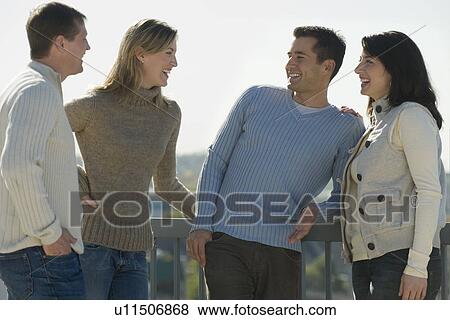 Couples talking on balcony View Large Photo Image Stock Photo - Couples talking on balcony. Fotosearch