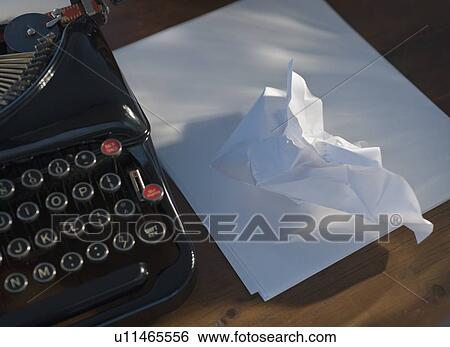 Stock Photograph - Crumpled paper next to antique typewriter. Fotosearch