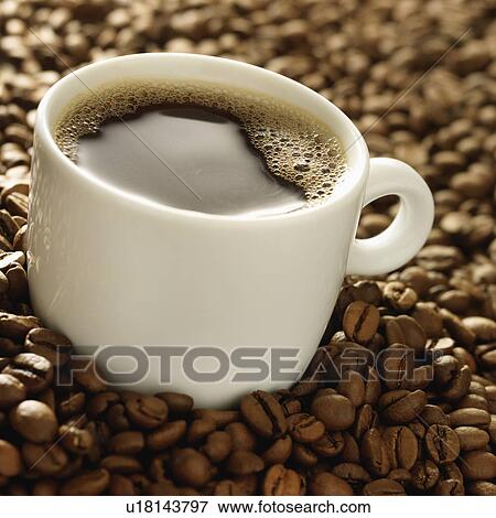 Cup of coffee surrounded by coffee beans View Large Photo Image Stock Photo - Cup of coffee surrounded by coffee beans. Fotosearch
