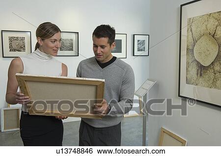 Curators examining painting in art gallery View Large Photo Image Stock Photograph - Curators examining painting in art gallery. Fotosearch