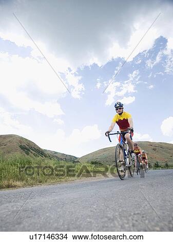 Cyclists in a row on country road View Large Photo Image Picture - Cyclists in a row on country road. Fotosearch