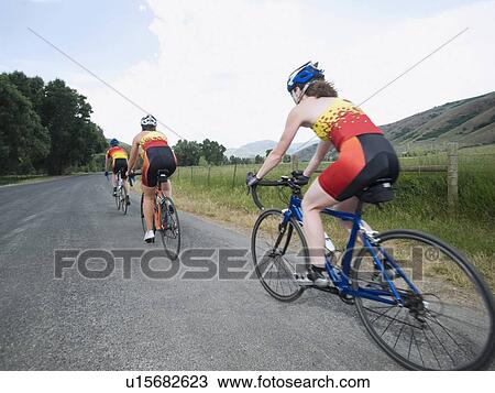 Stock Image - Cyclists in a row on country road. Fotosearch