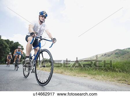 Stock Photo - Cyclists in a row on country road. Fotosearch