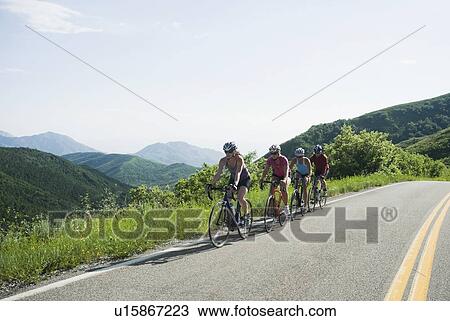 Stock Image - Cyclists in a row on mountain road. Fotosearch