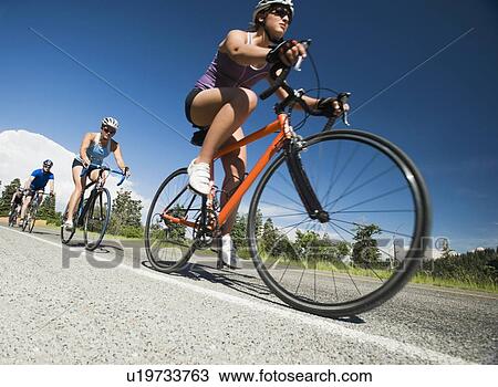 Stock Image - Cyclists in a row on mountain road. Fotosearch