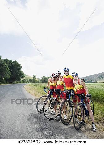 Cyclists posing on country road View Large Photo Image Stock Image - Cyclists posing on country road. Fotosearch