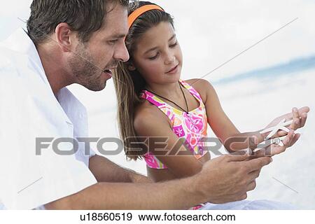 Daughter showing starfish to father View Large Photo Image Stock Photo - Daughter showing starfish to father. Fotosearch