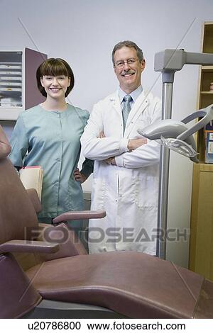 Stock Image - Dentist and dental hygienist in office. Fotosearch