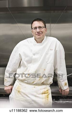 Stock Image - Dirty chef leaning against stove. Fotosearch