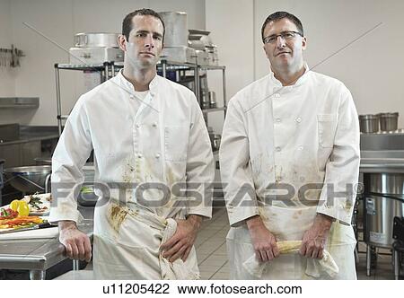 Stock Image - Dirty chefs posing in kitchen. Fotosearch