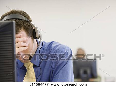 Stock Photo - Disappointed businessman wearing headset. Fotosearch