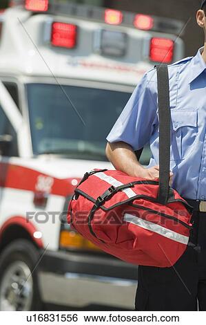 Stock Photograph - EMT carrying medical kit. Fotosearch