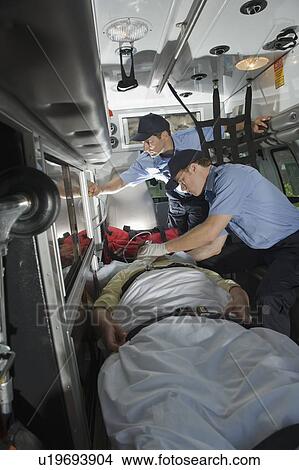 EMT’s caring for patient in ambulance View Large Photo Image Picture - EMT’s caring for patient in ambulance. Fotosearch