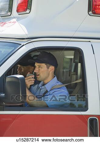Picture - EMT’s driving in ambulance. Fotosearch