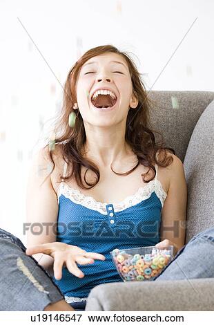 Stock Photo - Excited teenage girl tossing cereal in air. Fotosearch