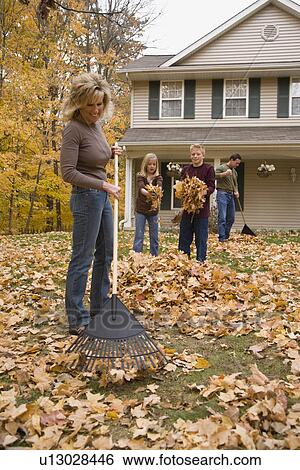 Stock Photograph - Family cleaning up autumn leaves. Fotosearch
