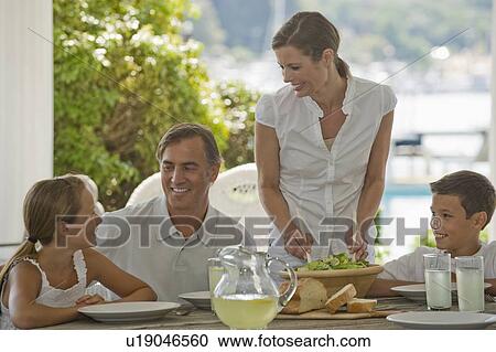 Stock Image - Family eating on porch. Fotosearch