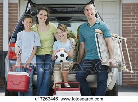 Family holding coolers and beach chair behind car View Large Photo Image Stock Photograph - Family holding coolers and beach chair behind car. Fotosearch