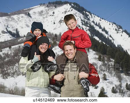 Stock Photo - Family in front of snowy mountain. Fotosearch