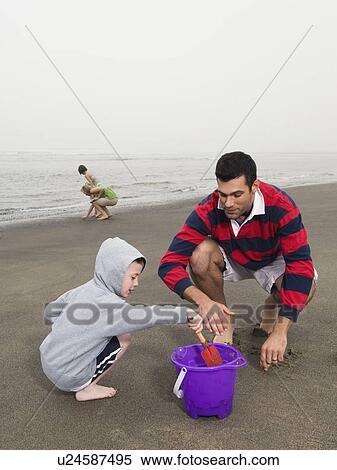 Family looking for shells on beach View Large Photo Image Stock Photography - Family looking for shells on beach. Fotosearch