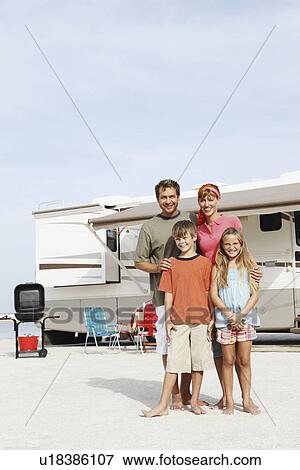 Stock Photo - Family posing by motor home on beach. Fotosearch