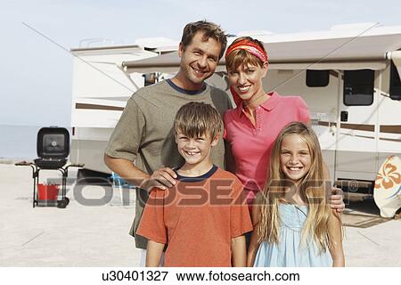 Stock Photo - Family posing by motor home on beach. Fotosearch