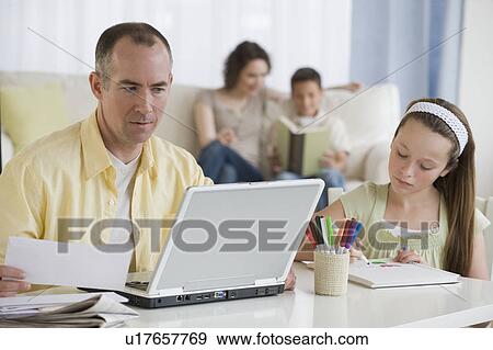Stock Photo - Family relaxing in living room. Fotosearch