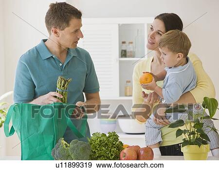 Stock Photo - Family unpacking groceries. Fotosearch