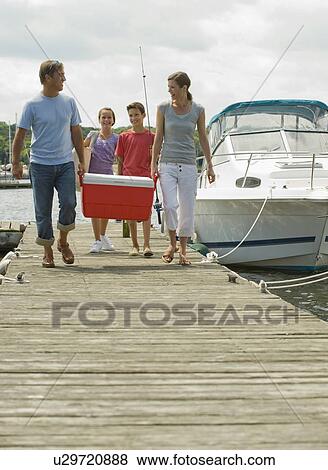 Stock Photo - Family walking on boat dock with cooler. Fotosearch