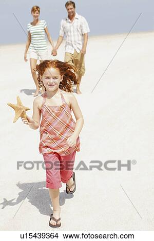 Picture - Family walking together on beach. Fotosearch