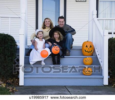 Stock Photo - Family with daughters dressed in witch and princess Halloween costumes. Fotosearch