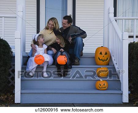 Stock Photograph - Family with daughters dressed in witch and princess Halloween costumes. Fotosearch