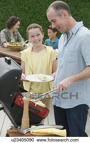 Family with two children barbecuing View Large Photo Image Stock Image - Family with two children barbecuing. Fotosearch