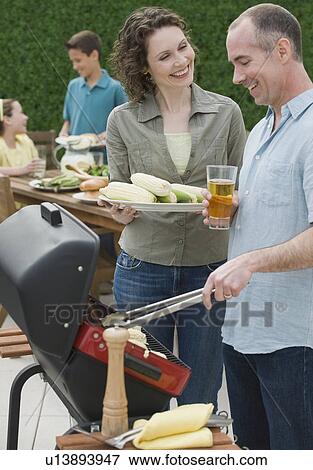Family with two children barbecuing View Large Photo Image Stock Photo - Family with two children barbecuing. Fotosearch