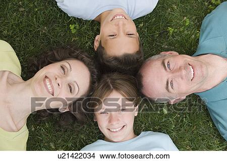 Picture - Family with two children laying on grass. Fotosearch