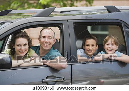 Stock Photo - Family with two children looking out car windows. Fotosearch