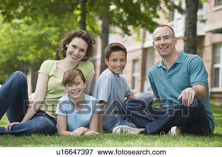 Stock Photo - Family with two children sitting on grass. Fotosearch