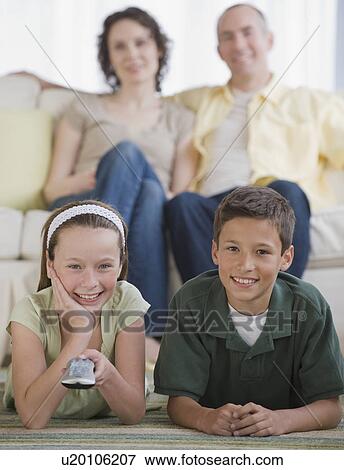 Family with two children watching television View Large Photo Image Stock Photo - Family with two children watching television. Fotosearch