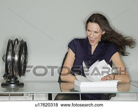 Fan blowing stack of papers at businesswoman’s desk View Large Photo Image Stock Photo - Fan blowing stack of papers at businesswoman’s desk. Fotosearch