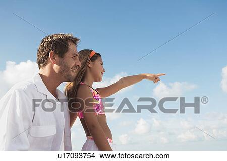 Picture - Father and daughter looking out to sea. Fotosearch