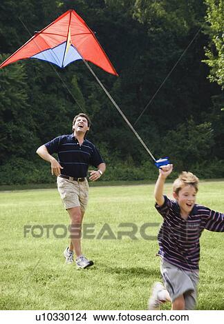 Father and son flying kite View Large Photo Image Picture - Father and son flying kite . Fotosearch