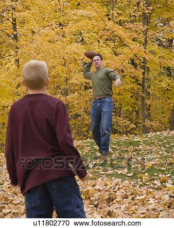 Stock Image - Father and son playing catch outdoors. Fotosearch