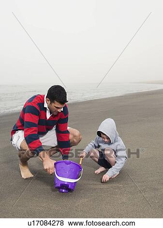 Father and son playing on beach View Large Photo Image Stock Photo - Father and son playing on beach. Fotosearch