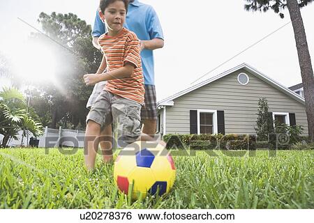 Father and son playing soccer in backyard View Large Photo Image Stock Photograph - Father and son playing soccer in backyard. Fotosearch