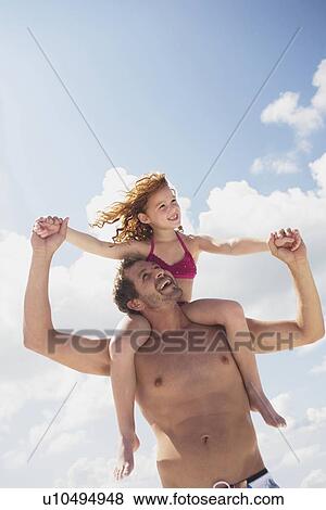 Stock Photo - Father carrying daughter in shoulders. Fotosearch